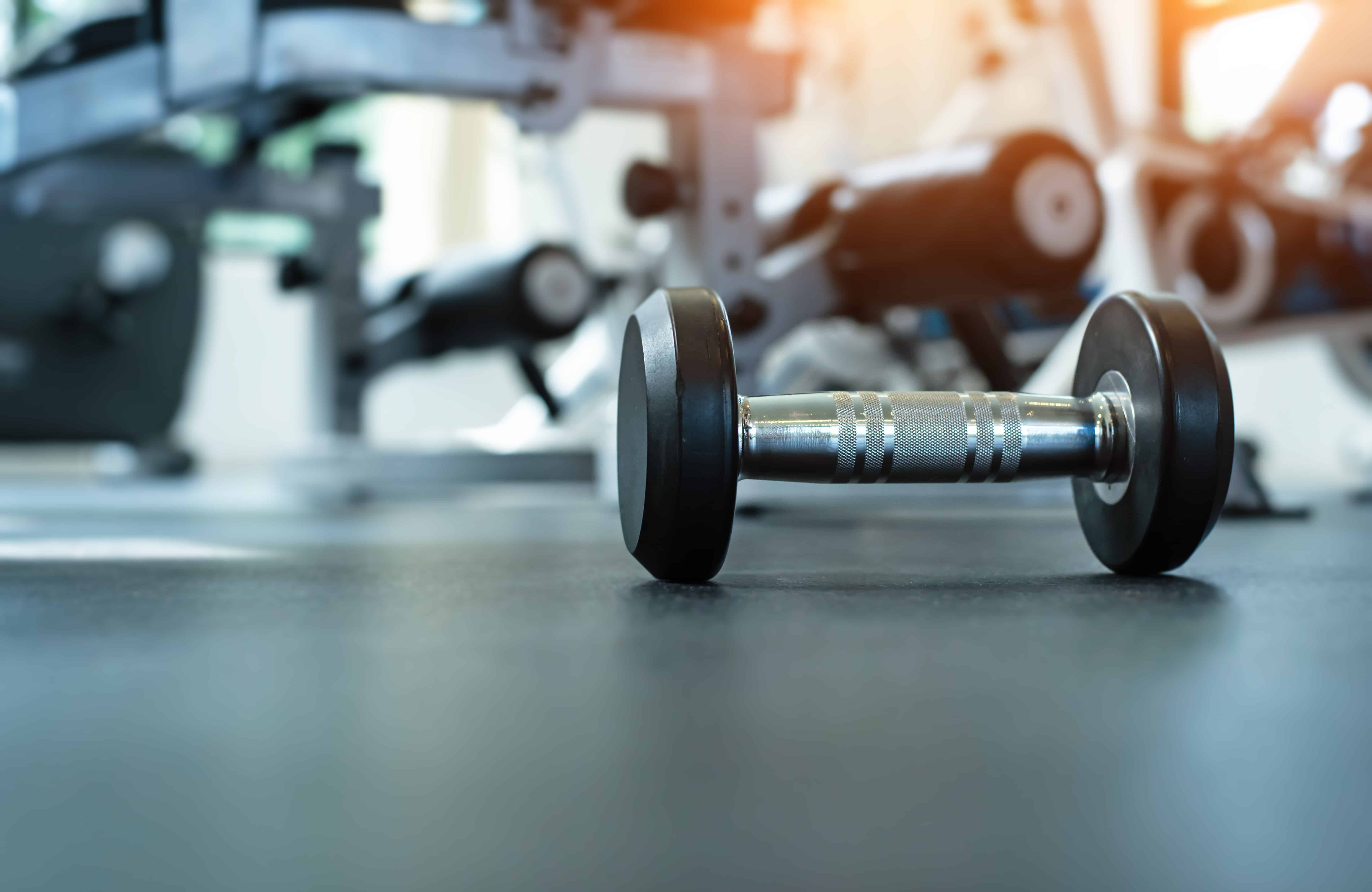 The dumbbell put on ground floor,at fitness room,warm light tone,blurry light around